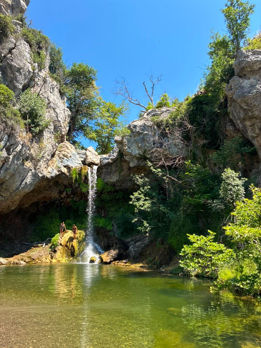 Waterfall falling into a green natural pool